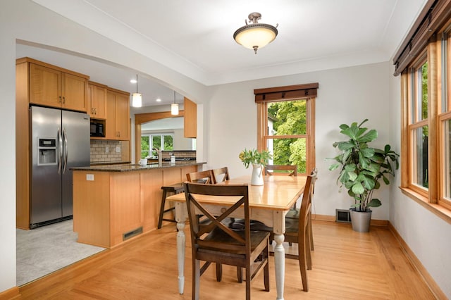 4313 Arthur St NE, Columbia Heights, MN 55421 - dining space featuring light wood-style flooring, healthy amount of natural light, arched walkways, baseboards, and recessed lighting
