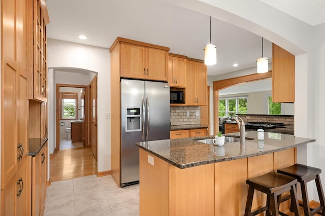 4313 Arthur St NE, Columbia Heights, MN 55421 - kitchen featuring stainless steel fridge, arched walkways, a sink, black microwave, and backsplash