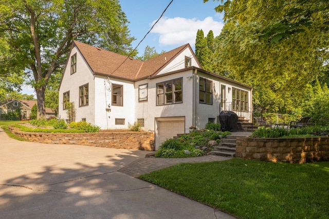 4313 Arthur St NE, Columbia Heights, MN 55421 - view of front of house featuring an attached garage, stucco siding, driveway, roof with shingles, and a front yard