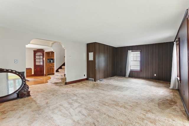 1206 2nd St W, Hastings, MN 55033 - unfurnished living room with arched walkways, light colored carpet, and stairs