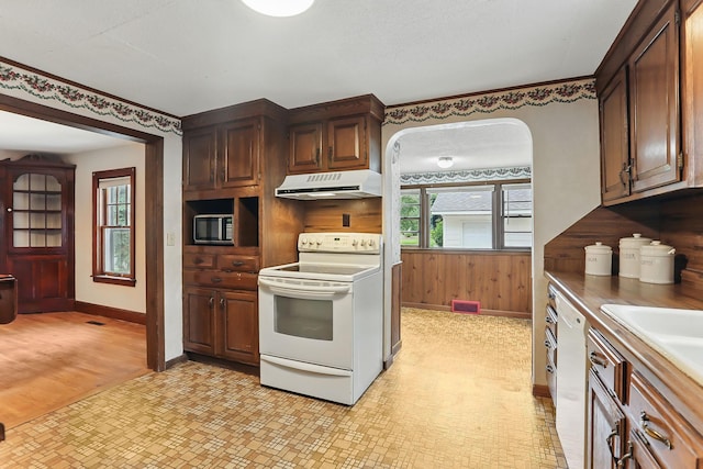 1206 2nd St W, Hastings, MN 55033 - kitchen with white appliances, exhaust hood, baseboards, healthy amount of natural light, and wooden walls