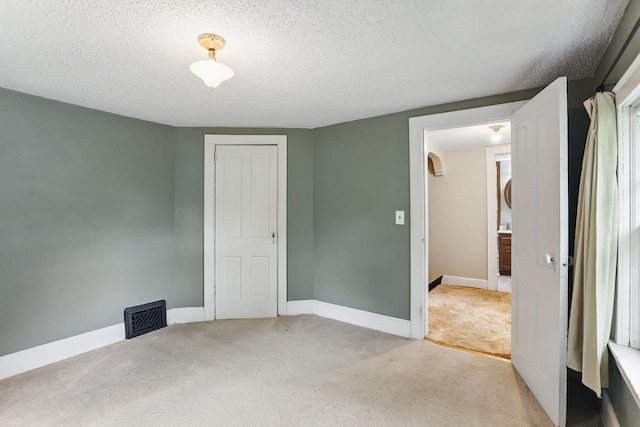 1206 2nd St W, Hastings, MN 55033 - unfurnished bedroom featuring light carpet, a textured ceiling, baseboards, and a closet
