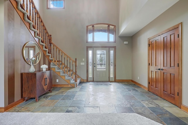 904 Ridgecrest Dr, Carver, MN 55315 - entryway featuring stone tile floors, a towering ceiling, and stairway