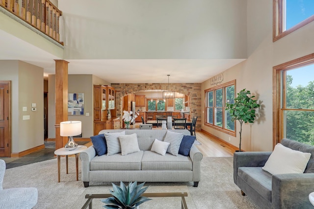 904 Ridgecrest Dr, Carver, MN 55315 - living area with a high ceiling, light wood finished floors, healthy amount of natural light, a chandelier, and ornate columns
