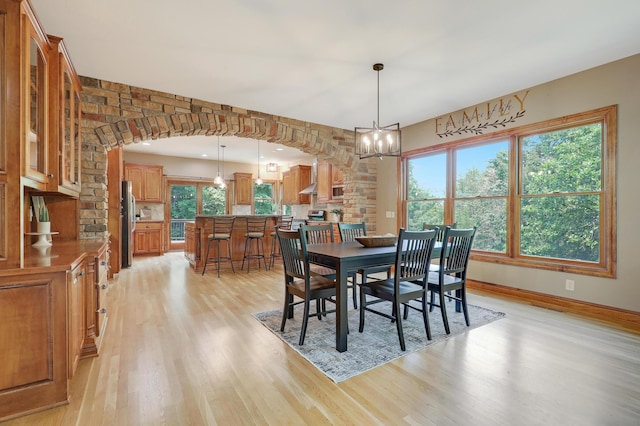 904 Ridgecrest Dr, Carver, MN 55315 - dining room with light wood-style flooring, a chandelier, and arched walkways