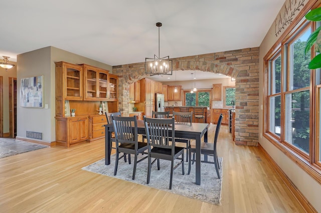 904 Ridgecrest Dr, Carver, MN 55315 - dining room with light wood-style floors, arched walkways, and a chandelier
