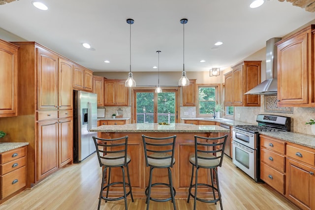 904 Ridgecrest Dr, Carver, MN 55315 - kitchen featuring stainless steel appliances, wall chimney range hood, light wood-style floors, a kitchen island, and light stone counters