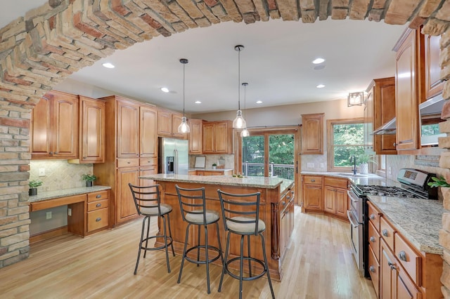 904 Ridgecrest Dr, Carver, MN 55315 - kitchen featuring appliances with stainless steel finishes, a center island, light wood-style floors, backsplash, and recessed lighting