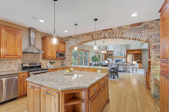 904 Ridgecrest Dr, Carver, MN 55315 - kitchen featuring stainless steel appliances, wall chimney range hood, light wood-style floors, open shelves, and light stone counters