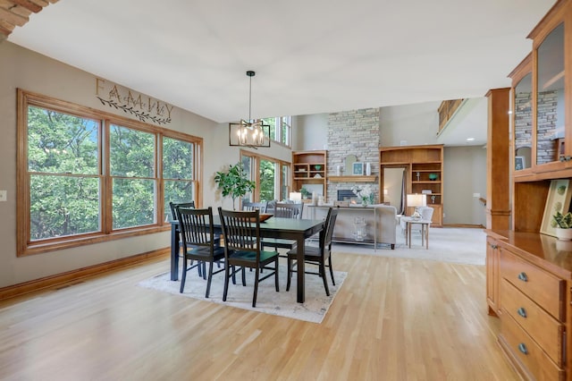 904 Ridgecrest Dr, Carver, MN 55315 - dining space with light wood-type flooring, a chandelier, and a fireplace