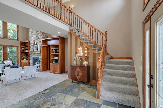 904 Ridgecrest Dr, Carver, MN 55315 - entrance foyer with a towering ceiling, a stone fireplace, stairs, stone finish floors, and carpet floors