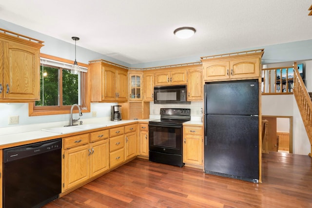 2745 Maplewood Cir, Monticello, MN 55362 - kitchen featuring black appliances, a sink, dark wood-type flooring, light countertops, and decorative light fixtures