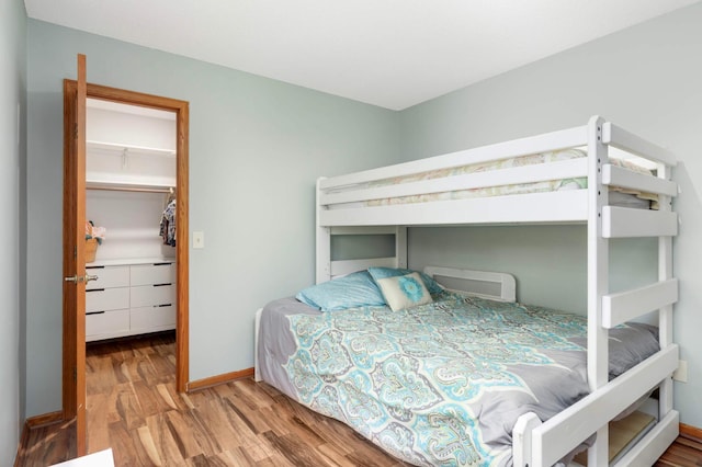 2745 Maplewood Cir, Monticello, MN 55362 - bedroom featuring a spacious closet, wood finished floors, a closet, and baseboards