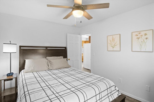 311 Franklin St, Lake City, MN 55041 - bedroom with freestanding refrigerator, baseboards, a ceiling fan, and wood finished floors