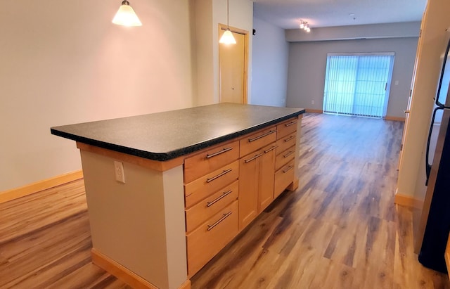 1805 3rd Ave S Unit 102, Minneapolis, MN 55404 - kitchen featuring light wood finished floors, dark countertops, a center island, and hanging light fixtures