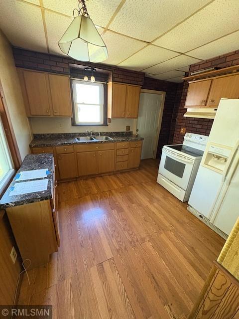 1539 Iglehart Ave, Saint Paul, MN 55104 - kitchen featuring white electric range, under cabinet range hood, a sink, light wood-style floors, and dark countertops