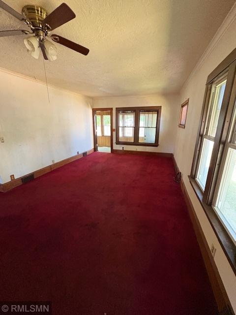 1539 Iglehart Ave, Saint Paul, MN 55104 - empty room featuring dark carpet, a textured ceiling, healthy amount of natural light, baseboards, and ornamental molding
