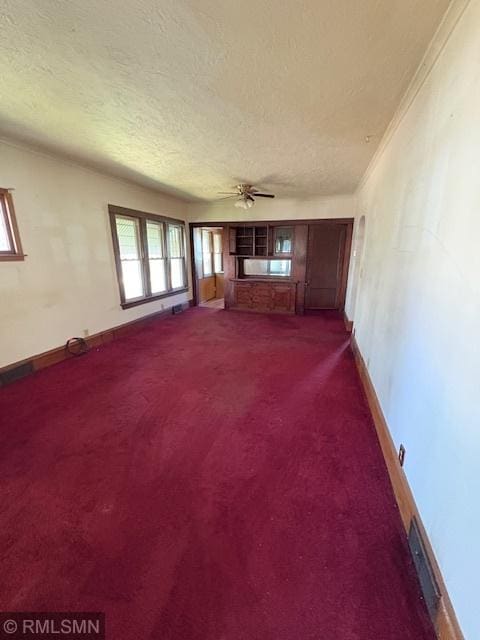 1539 Iglehart Ave, Saint Paul, MN 55104 - unfurnished living room featuring a textured ceiling, dark carpet, a ceiling fan, baseboards, and crown molding