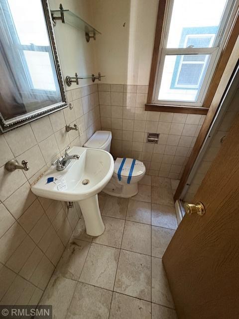 1539 Iglehart Ave, Saint Paul, MN 55104 - bathroom with toilet, tile walls, tile patterned floors, and a sink