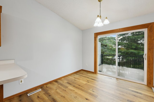 14737 Endicott Way, Apple Valley, MN 55124 - unfurnished dining area featuring a chandelier, baseboards, light wood finished floors, and vaulted ceiling