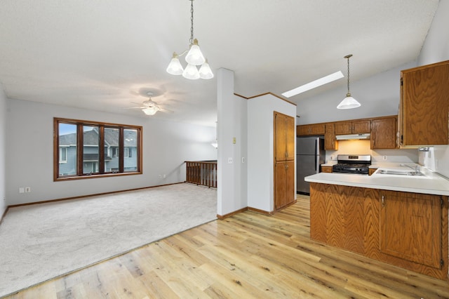 14737 Endicott Way, Apple Valley, MN 55124 - kitchen with appliances with stainless steel finishes, under cabinet range hood, brown cabinets, a sink, and a peninsula