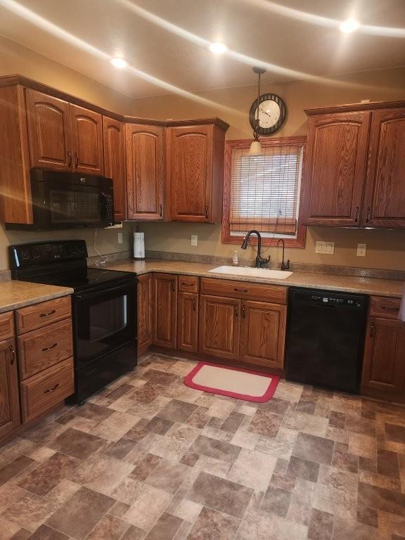 313 2nd St, Hills, MN 56138 - kitchen featuring black appliances, a sink, brown cabinets, and light countertops