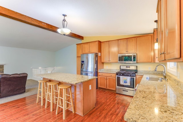 8317 Penn Ave N, Brooklyn Park, MN 55444 - kitchen with appliances with stainless steel finishes, a sink, open floor plan, light stone counters, and a breakfast bar
