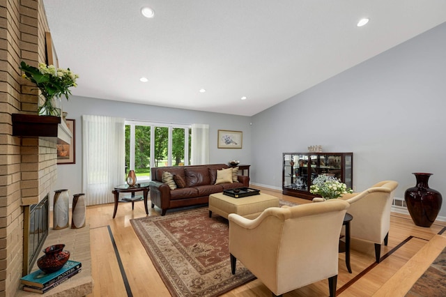 2367 Apache Ct, Mendota Heights, MN 55120 - living room with a brick fireplace, light wood-style floors, recessed lighting, and lofted ceiling