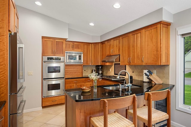 2367 Apache Ct, Mendota Heights, MN 55120 - kitchen with appliances with stainless steel finishes, tasteful backsplash, ventilation hood, a peninsula, and brown cabinets