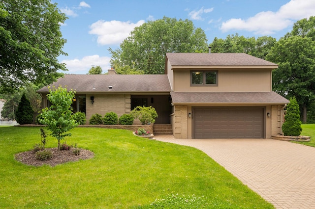 2367 Apache Ct, Mendota Heights, MN 55120 - tri-level home featuring a garage, decorative driveway, a front lawn, a chimney, and brick siding