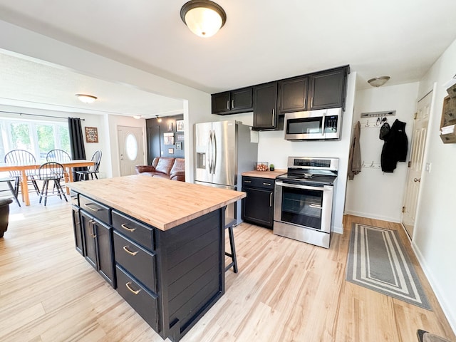 810 Division St, Elbow Lake, MN 56531 - kitchen with appliances with stainless steel finishes, butcher block counters, a breakfast bar area, and light wood-type flooring