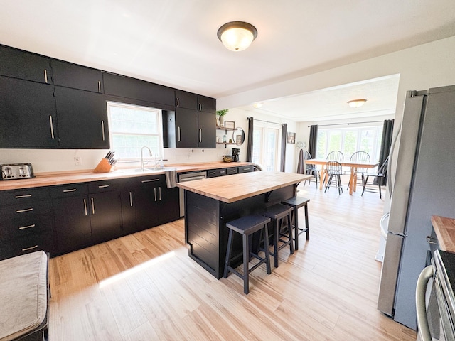 810 Division St, Elbow Lake, MN 56531 - kitchen featuring butcher block counters, dark cabinets, and plenty of natural light