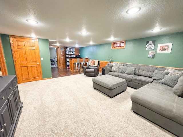 810 Division St, Elbow Lake, MN 56531 - living area featuring a textured ceiling, dark colored carpet, bar, and recessed lighting