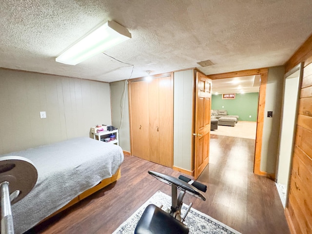 810 Division St, Elbow Lake, MN 56531 - bedroom featuring wood finished floors, a textured ceiling, wooden walls, and a closet