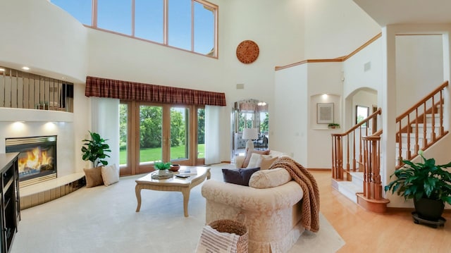 E5110 Interlachen Blvd, Pleasant Valley Twp, WI 54738 - living area with a towering ceiling, a glass covered fireplace, arched walkways, and stairs