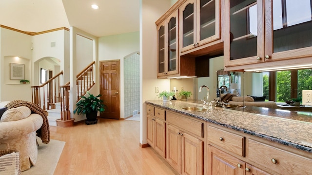 E5110 Interlachen Blvd, Pleasant Valley Twp, WI 54738 - kitchen with a sink, light wood-type flooring, arched walkways, glass insert cabinets, and a high ceiling