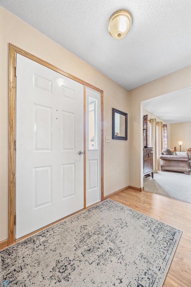 5701 33rd St S, Fargo, ND 58104 - foyer entrance with wood finished floors, baseboards, and a textured ceiling