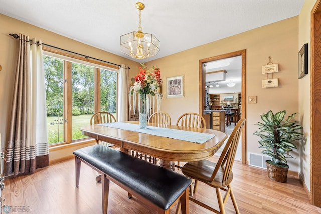 5701 33rd St S, Fargo, ND 58104 - dining area featuring a chandelier, baseboards, plenty of natural light, and light wood-style floors