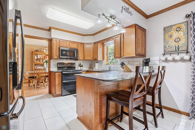 5701 33rd St S, Fargo, ND 58104 - kitchen featuring stainless steel microwave, range with two ovens, black fridge with ice dispenser, a peninsula, and ornamental molding
