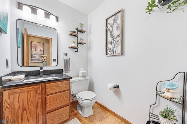 5701 33rd St S, Fargo, ND 58104 - half bathroom with toilet, vanity, wood finished floors, and baseboards