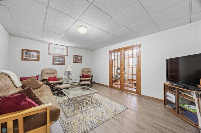 5701 33rd St S, Fargo, ND 58104 - living room featuring french doors, wood finished floors, a drop ceiling, and baseboards