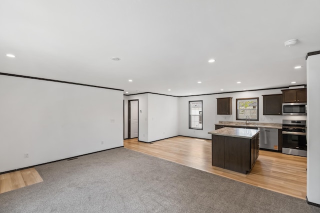 215 Mckay Ave # 42, Alexandria, MN 56308 - kitchen featuring appliances with stainless steel finishes, a sink, dark brown cabinetry, light countertops, and open floor plan
