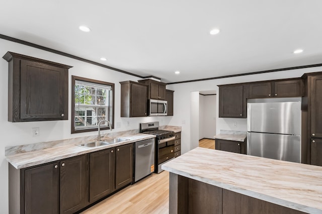 215 Mckay Ave # 42, Alexandria, MN 56308 - kitchen with appliances with stainless steel finishes, a sink, dark brown cabinets, light countertops, and ornamental molding