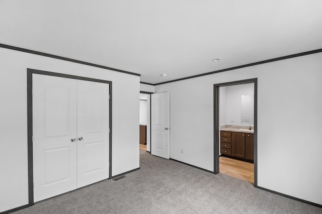 215 Mckay Ave # 42, Alexandria, MN 56308 - unfurnished bedroom featuring light colored carpet, crown molding, baseboards, a closet, and ensuite bath