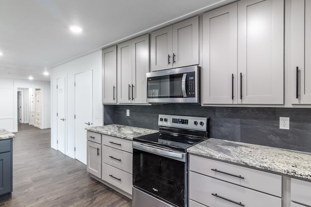 1020 1st St S, Cold Spring, MN 56320 - kitchen featuring appliances with stainless steel finishes, dark wood-type flooring, backsplash, recessed lighting, and light stone countertops