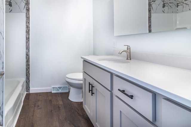 1020 1st St S, Cold Spring, MN 56320 - bathroom featuring vanity, toilet, wood finished floors, and baseboards