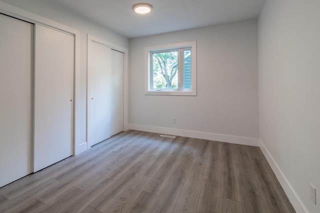1020 1st St S, Cold Spring, MN 56320 - unfurnished bedroom featuring wood finished floors, two closets, and baseboards
