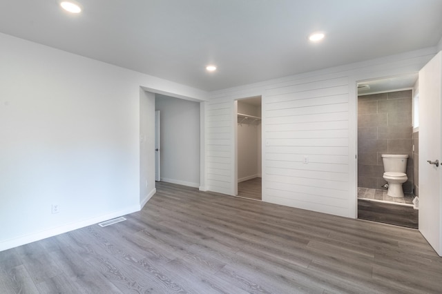 1020 1st St S, Cold Spring, MN 56320 - unfurnished bedroom featuring wood finished floors, recessed lighting, a spacious closet, ensuite bath, and a closet