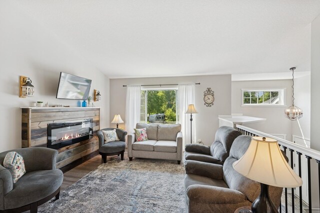 13362 Jefferson St, Becker, MN 55308 - living area featuring plenty of natural light, wood finished floors, a glass covered fireplace, and a chandelier