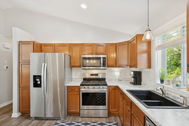 13362 Jefferson St, Becker, MN 55308 - kitchen with appliances with stainless steel finishes, vaulted ceiling, a sink, tasteful backsplash, and brown cabinetry